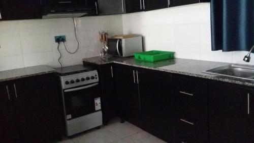 Una cocina con estufa y fregadero. en Mist Stay Inn, en Ruhengeri