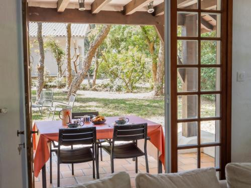 une table et des chaises assises sur une terrasse dans l'établissement Maison Landaise proche plage& centre-ville !, à Seignosse