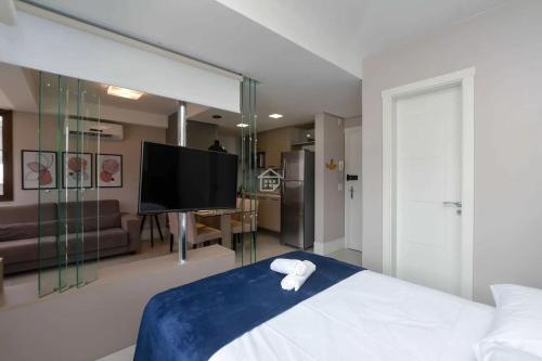 a hotel room with a bed and a tv at Lindo Apartamento próximo ao parque em Porto Alegre! in Floresta