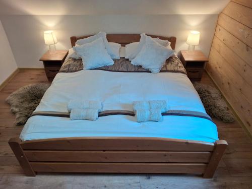 a bedroom with a large bed with two lamps on tables at Domek z widokiem in Istebna
