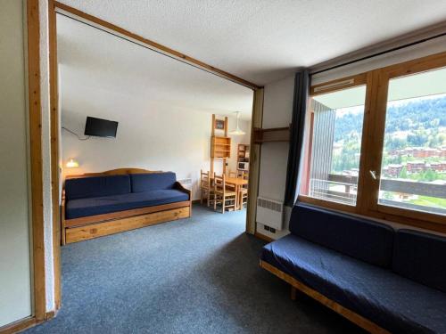 une chambre avec un lit et une grande fenêtre dans l'établissement Résidence Cachette G - CACHETTE 22 MAE-8061, à Valmorel