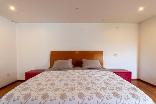 a bedroom with a large bed with a wooden headboard at Luxury and tranquility facing the sea in Quintay