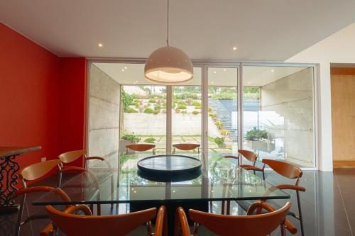 a dining room with a glass table and chairs at Luxury and tranquility facing the sea in Quintay