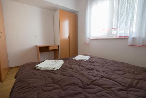 a bedroom with a bed with two towels on it at Apartments&Rooms SB in Neum