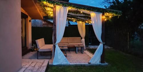 een prieel met een tafel, stoelen en verlichting bij Vineyard Apartment in Ohrid