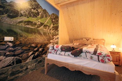 a bedroom with a bed with a painting on the wall at Góralski Domek Waluś Zakopane - ŚCISŁE CENTRUM - Jedyny domek na Krupówkach in Zakopane