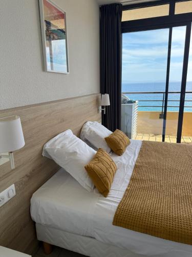 une chambre avec un lit avec vue sur l'océan dans l'établissement Beau Studio vue sur mer, route des sanguinaires, à Ajaccio