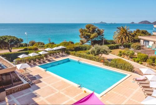 une piscine avec l'océan en arrière-plan dans l'établissement Beau Studio vue sur mer, route des sanguinaires, à Ajaccio