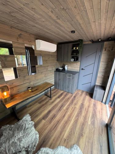 sala de estar con suelo de madera y mesa en Sidrabgrava - Luxury cabin in woods, en Limbaži