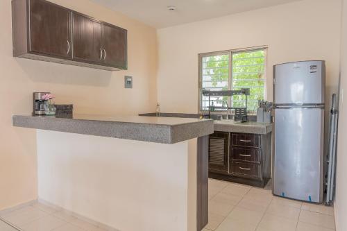 a kitchen with a refrigerator and a counter top at Amplia casa con 3 habitaciones para hospedaje in Chetumal