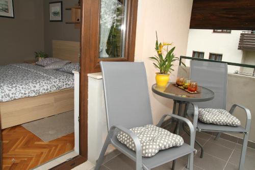 a small room with a bed and a table and chairs at Apartments Strmac in Slunj