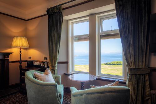 a room with two chairs and a table and two windows at Flodigarry Hotel in Staffin