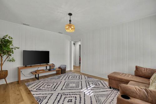 a living room with a couch and a flat screen tv at It's A Vibe- less than 10mins Capital,Hospitals,FAMU,&FSU in Tallahassee
