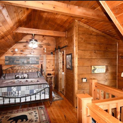 a bedroom with a bed in a log cabin at Bear Country Cabin in Sevierville