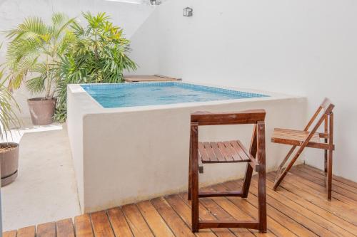 a swimming pool with a chair and a table at Amplia casa con 3 habitaciones para hospedaje in Chetumal