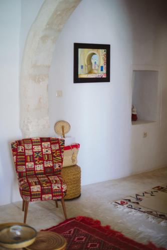 a room with a chair and a picture on the wall at Dar Naël in Houmt Souk
