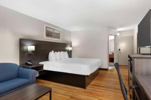 a hotel room with a bed and a blue chair at Best Western Mystic Hotel in Mystic