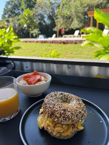 un bagel sur une table avec un verre de jus d'orange dans l'établissement Yumas Riverfront Lodge, à San Ignacio
