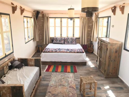 a bedroom with two beds in a room with windows at Villa Des Arts in Essaouira