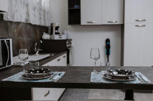 a kitchen with a table with glasses and plates on it at House Paradise- House Arena in Porticello