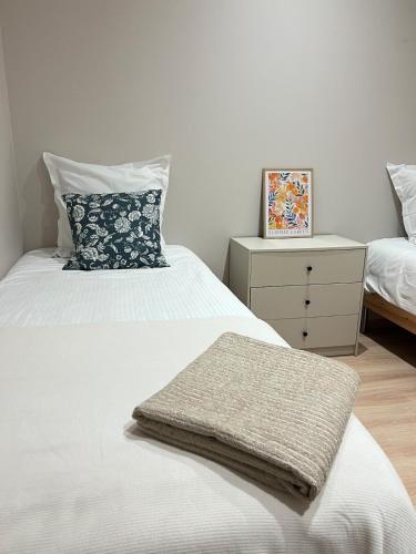 - une chambre avec 2 lits et une commode avec un oreiller dans l'établissement Appartement Saint-Louis, à Verdun-sur-Meuse