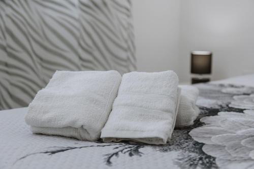 a pile of towels sitting on top of a bed at House Paradise- House Arena in Porticello