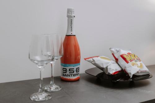 a bottle of beer and two glasses on a table at House Paradise- House Arena in Porticello