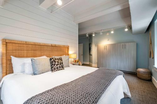 a bedroom with a large white bed with a wooden headboard at Nashville Honky Tonk Suite 6 BR by Maddox Hotel in Nashville