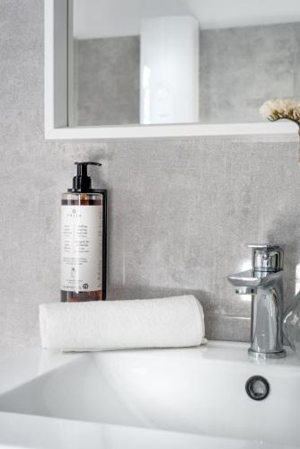 a bathroom sink with a bottle of soap and a towel at Apartament TU Cichowo in Cichowo
