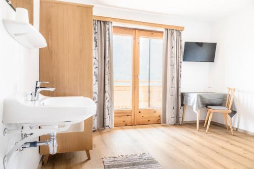 a bathroom with a sink and a window at Ferienwohnungen Windischlehen am Zeller See in Maishofen