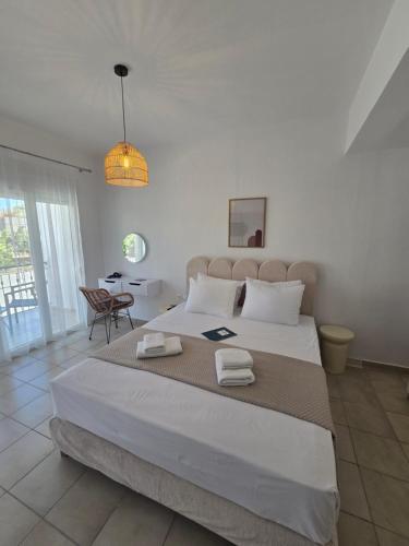 una camera da letto con un letto grande e un tavolo di White Pebble a Città di Skiathos