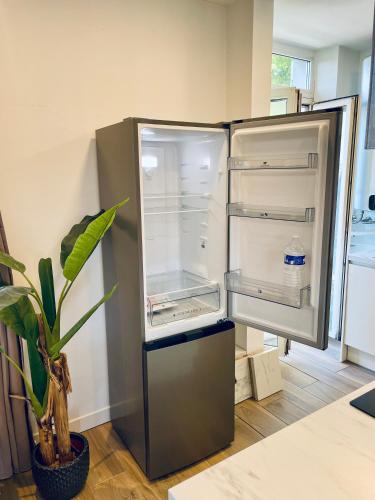 un réfrigérateur vide dans une cuisine avec une plante dans l'établissement T3 Lumineux & Cosy avec Balcon Escapade by DarBonne, à Narbonne