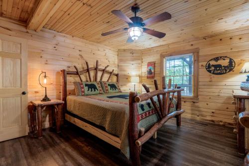 Blockhausschlafzimmer mit einem Bett und einem Deckenventilator in der Unterkunft Gorgeous 32in GatlinburgwFree Tickets to Dollywood,Anakeesta,AquariumClose2RockyTopSportsWorld in Gatlinburg