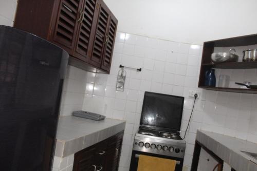 a small kitchen with a stove and a microwave at Blessing Holiday Homes - Diani Beach in Diani Beach