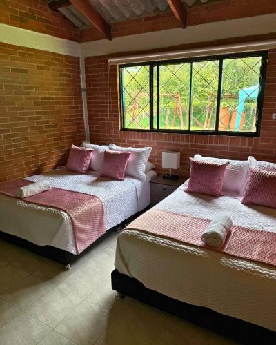 two beds in a room with a brick wall at Eco Boutique House in La Vega