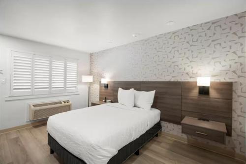 a bedroom with a large white bed and a window at Geary Parkway Motel in San Francisco