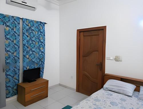 a bedroom with a bed and a wooden door at Villa Privée in Abomey-Calavi