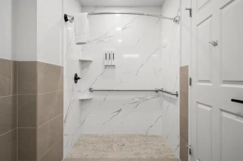 a white bathroom with a shower with a glass door at Geary Parkway Motel in San Francisco