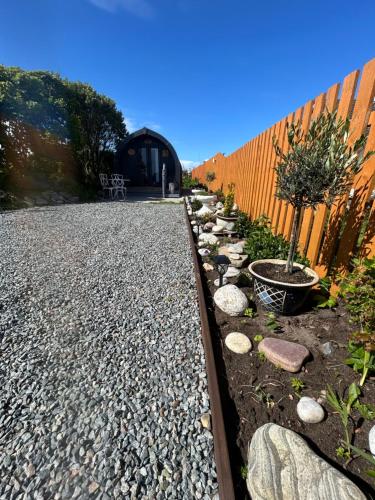 a garden with a gravel path and a fence at Taigh Plo in Lionel
