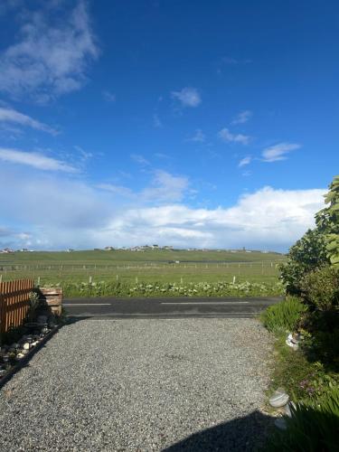 a driveway with a field of crops in the background at Taigh Plo in Lionel