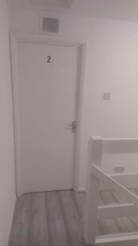 a white room with a door and a closet at Modern Apartment in Southeast London in Plumstead