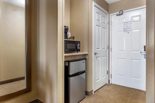 a small kitchen with a microwave and a door at Comfort Inn Gurnee near Six Flags in Gurnee