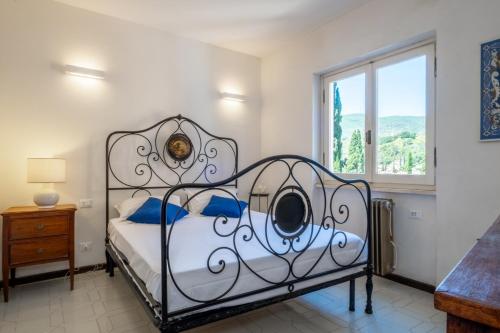 a bedroom with a bed with blue pillows and a window at Villa Consani Charming House by Varental in Porto Ercole
