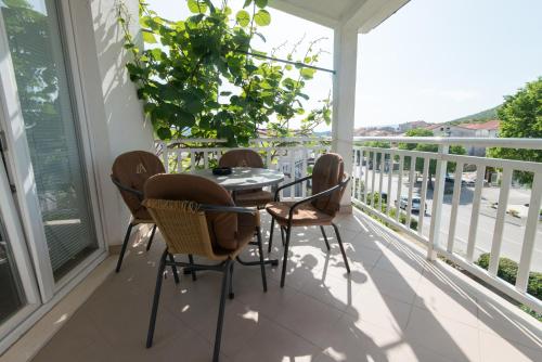 a porch with a table and chairs on a balcony at Apartments&Rooms SB in Neum