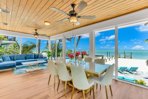 Un comedor con mesa y sillas y el océano. en BeachFront Luxury island Home, en Captiva