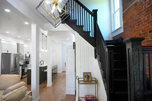 a staircase in a living room with a brick wall at St. Louis Luxury Home 3BR/3.5BA Near Everything in Soulard
