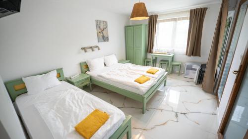 a room with two beds in it with yellow towels at Airport Károly Centrál in Vecsés
