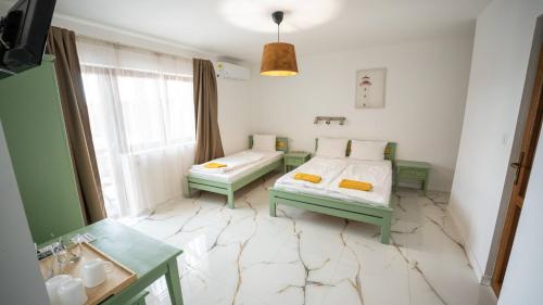 a room with two beds and a bathroom with a sink at Airport Károly Centrál in Vecsés