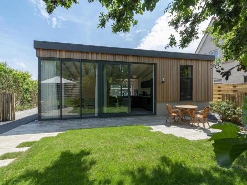 a glass house with a table and chairs at Attractive home with terrace in Callantsoog