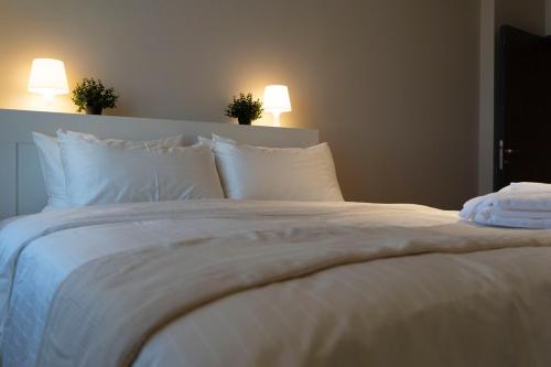 a white bed with white pillows in a bedroom at Apartment in Alkhoud Muscat in Maţār as Sīb ad Duwalī